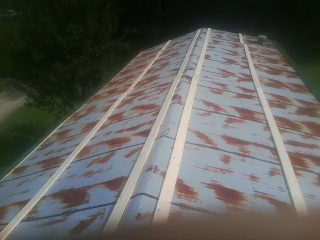 Rusted metal roof panels with new wood purlins before replacement — Storm Damage Roof Repair in Chesapeake Beach by Roofing Brothers