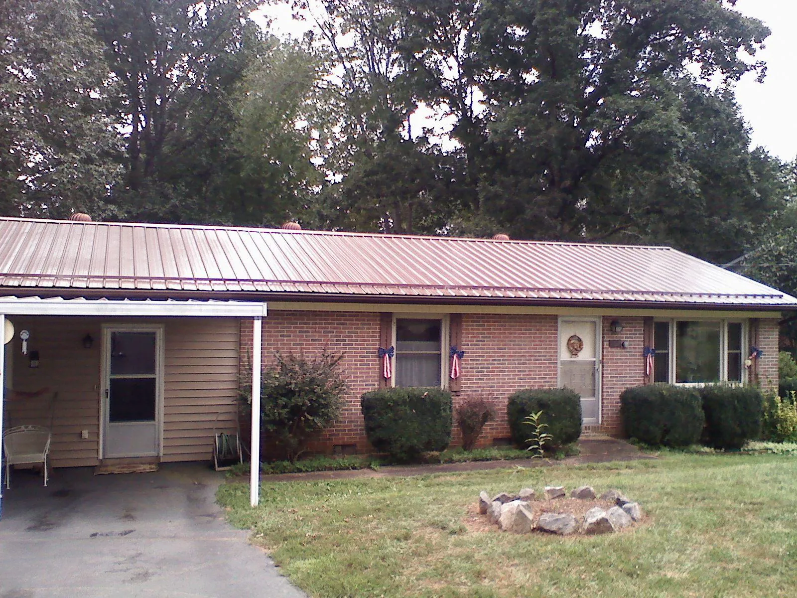 Bronze metal roof and carport on a brick ranch home — Roof Repair work by our crew in Chesapeake Beach
